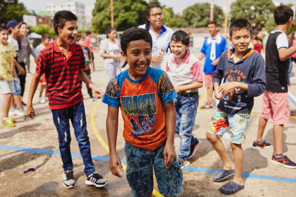 Vrolijke kinderen hebben waterpret op het schoolplein