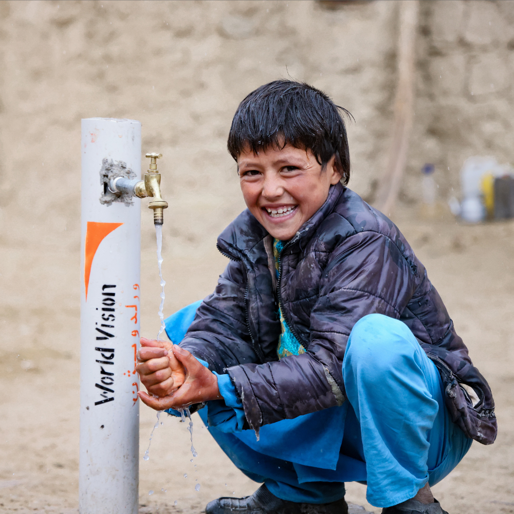 Jongen die zijn handen wast bij een World Vision kraan.