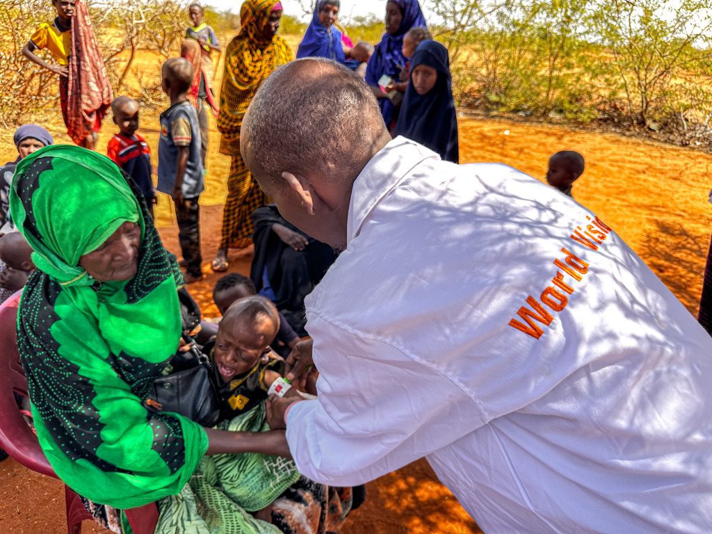 World Vision medewerker helpt kind