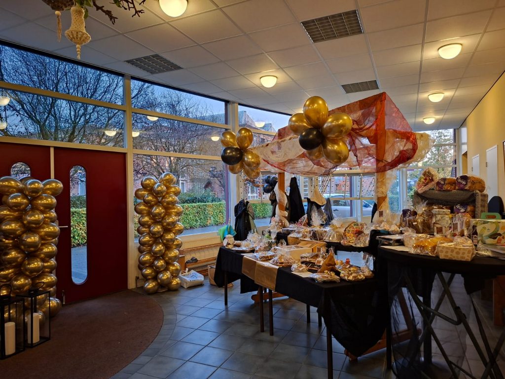 De tafel met gebakken lekkers en boeken tijdens het jubileum concert van Testify - opbrengst voor World Vision.