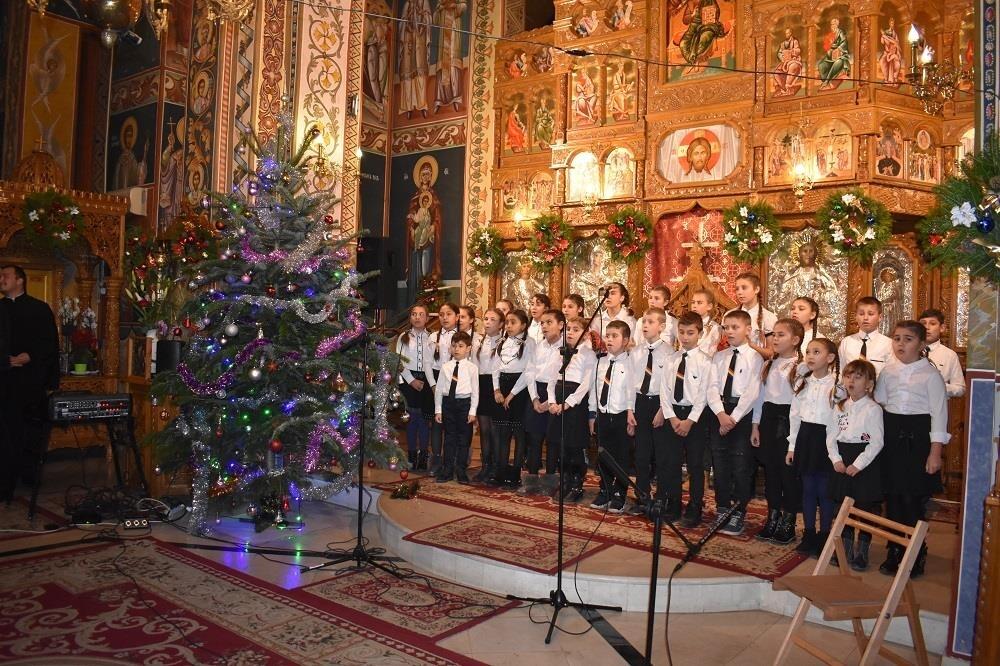 Kinderen die gesponsord worden, zingen kerstliederen in een kerk.
